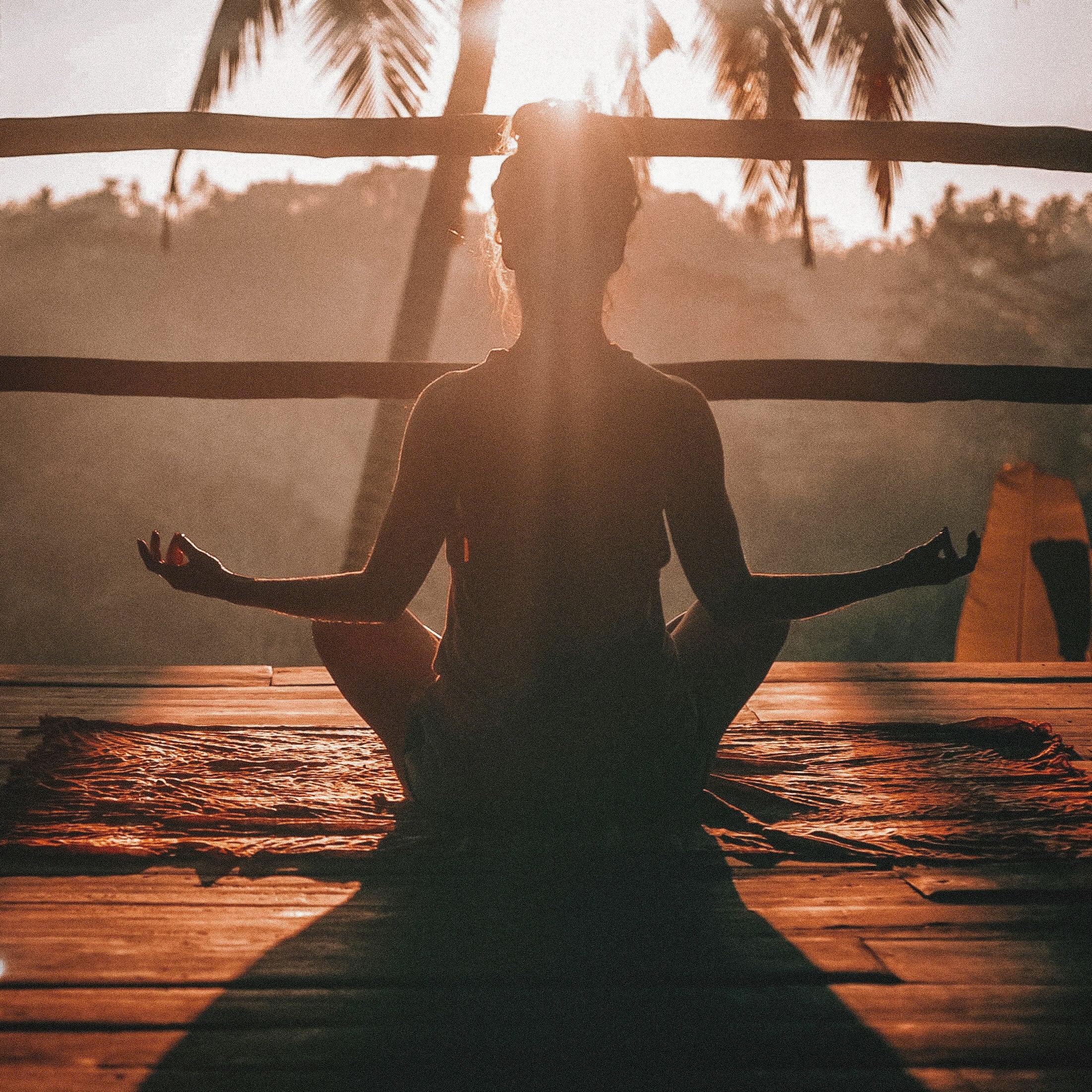 Woman meditating at sunset