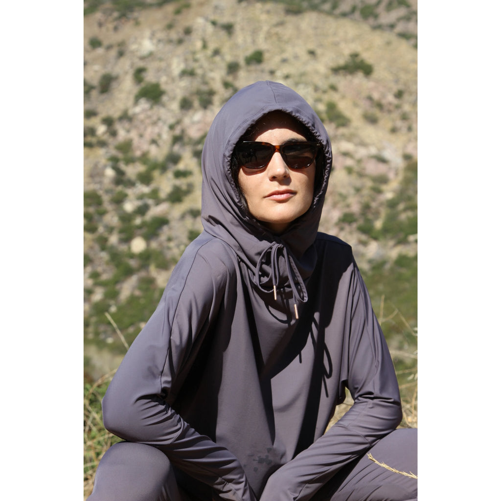 Woman outdoors wearing a lightweight, long sleeved sun protective plum hoodie with hand coverings and matching UPF 50+ drawstring pants.