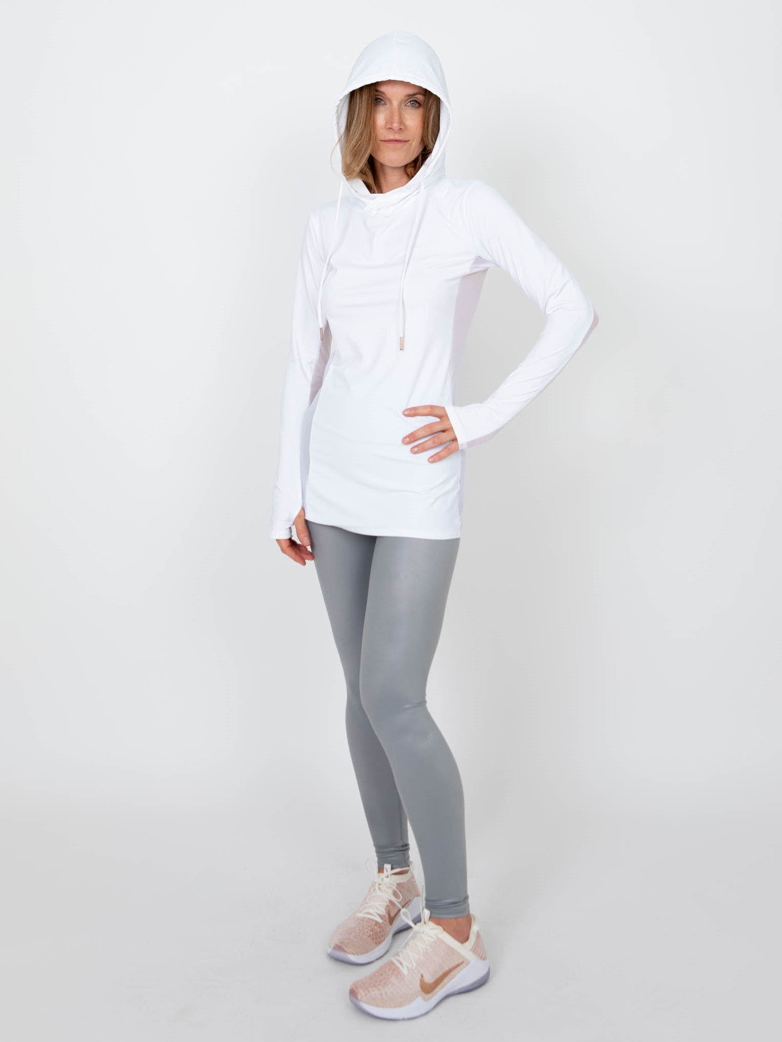 Woman wearing a long-sleeved UPF 50+ (sun protective) shirt with full hood and hand protection in white.